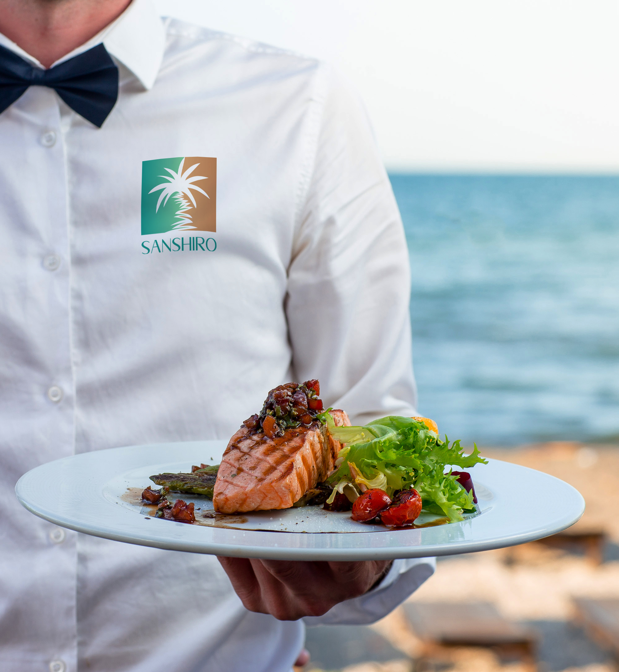 waiter holds plate grilled smoked salmon with lettuce tomato pepper